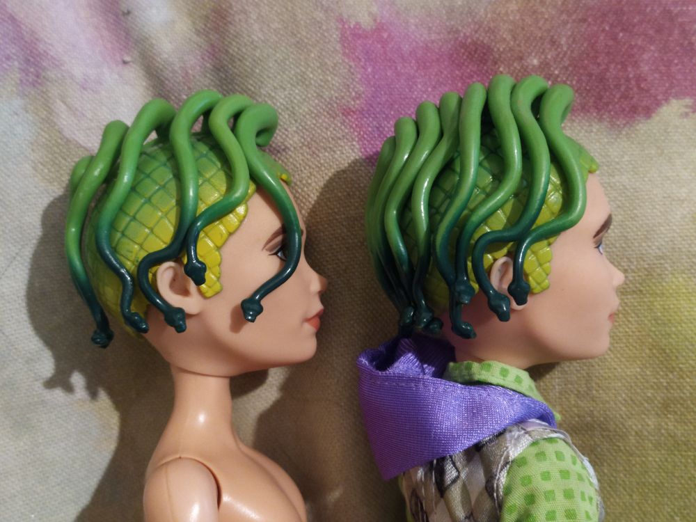 Side shot of two Monster High dolls, Deuce Dawn of the Dance. The one on the right is missing one snake at the front (left side); the one on the left is missing half the snakes (all the right side)