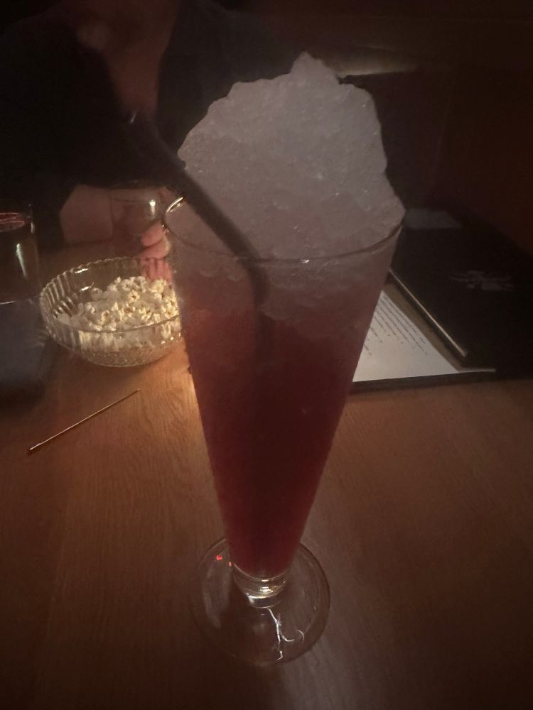 A tall red drink full of ice. 