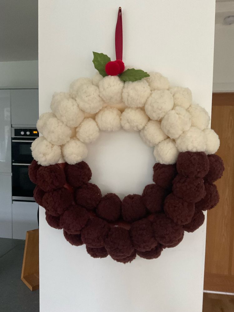 A wreath made from Pom poms made to look like a Christmas pudding