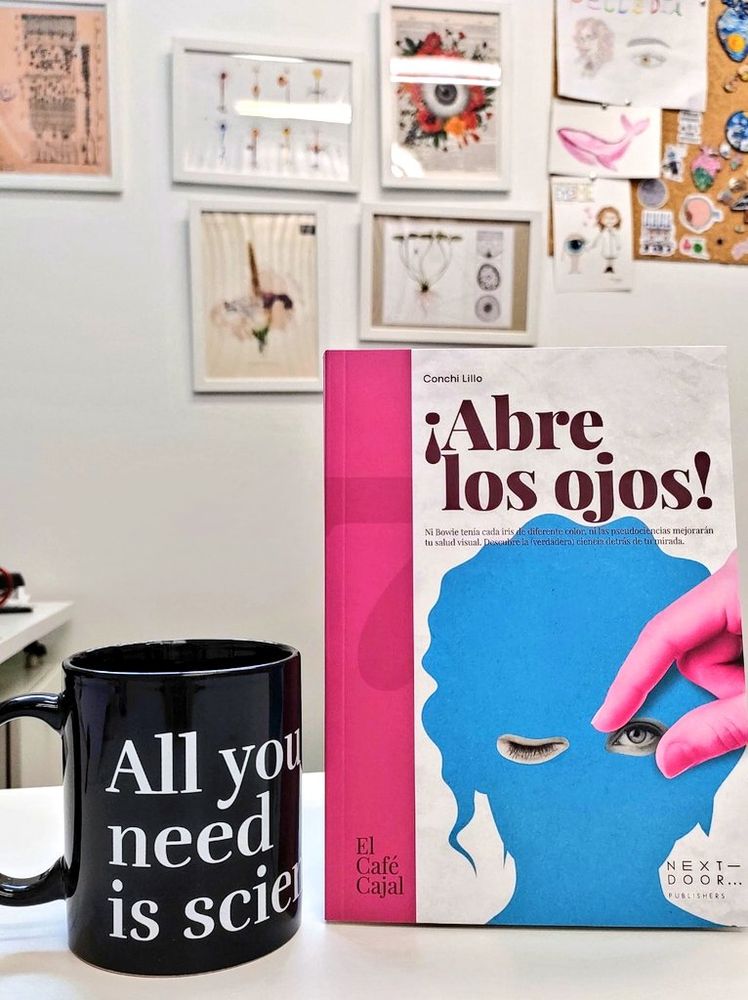 Portada del libro ¡Abre los Ojos! que publiqué con Next Door Publishers y una taza de la editorial donde se lee: All you need is Science y de fondo se ve la pared de mi despacho
