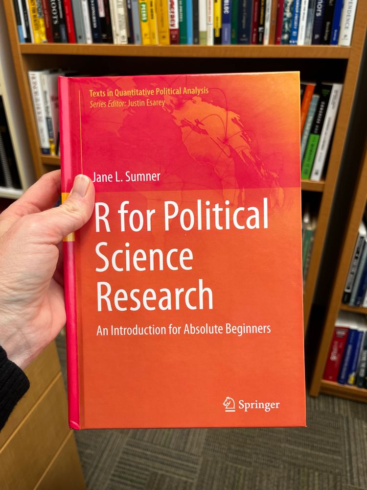 A photo of a book, “R for Political Science Research.”