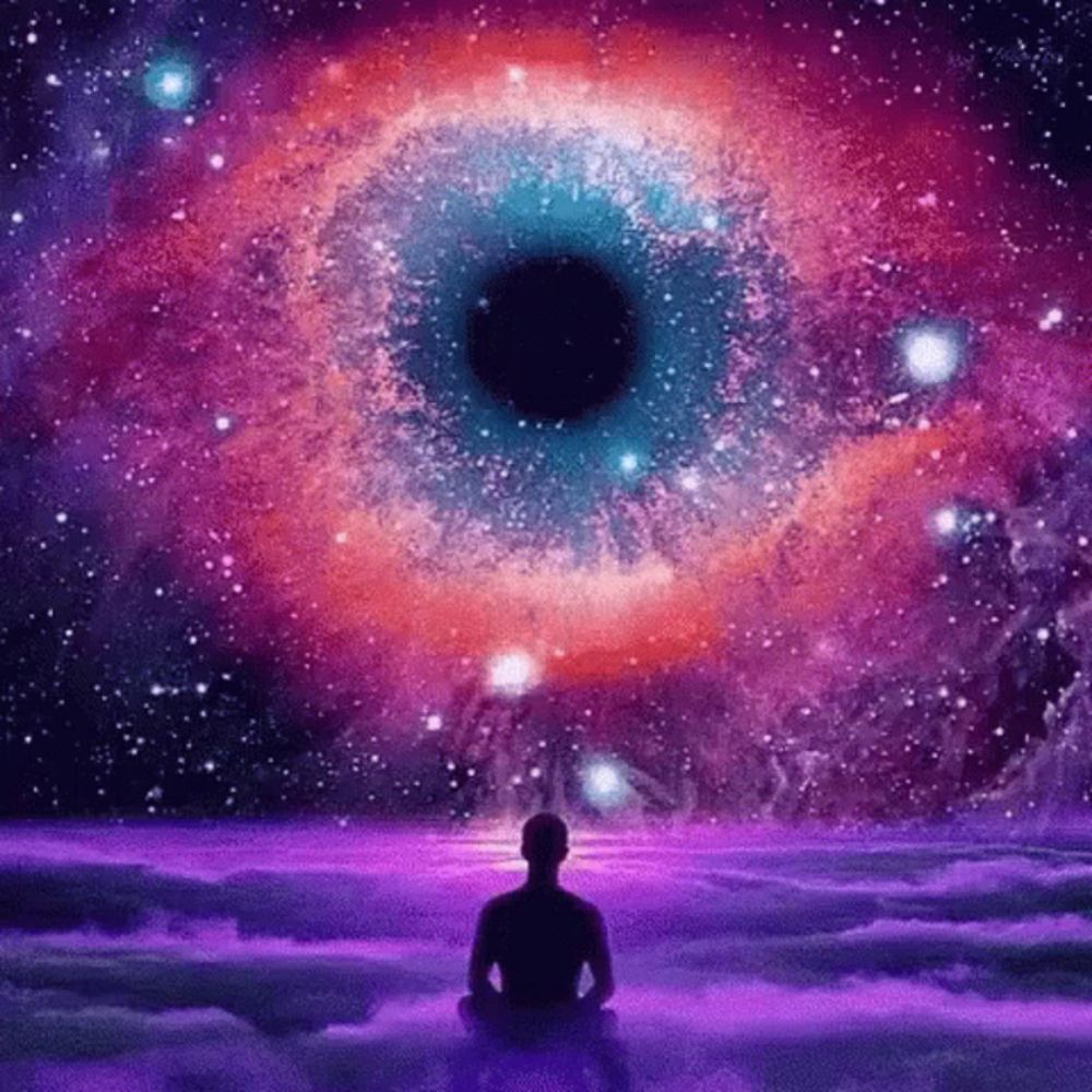 a man is sitting in a lotus position in front of a galaxy .