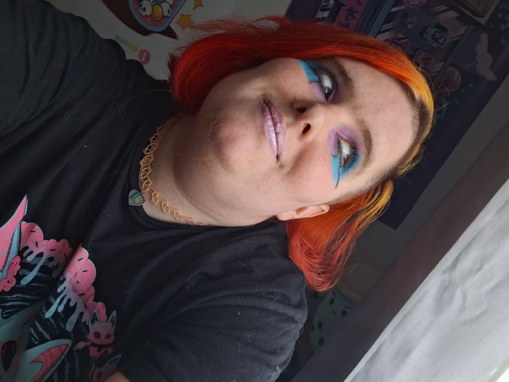 Raven at home wearing pink and blue eyeshadow and pink lippy.