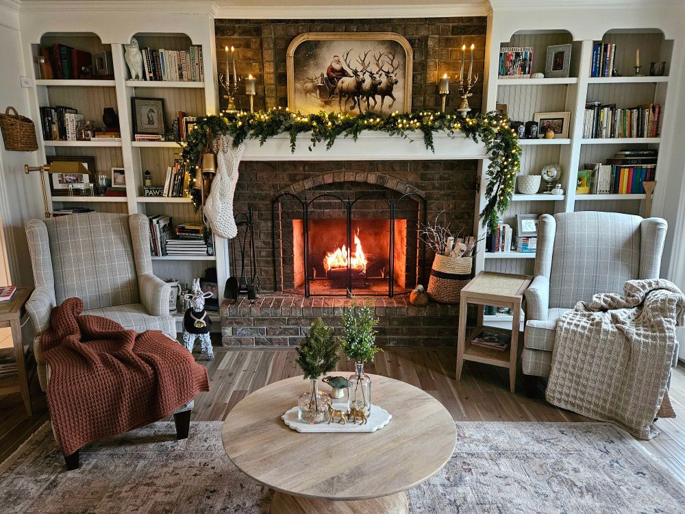 Cozy living room setup for Christmas with a fire in the fireplace. 