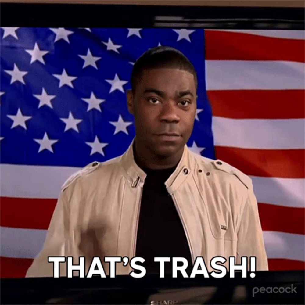 a man standing in front of an american flag with the words that 's trash