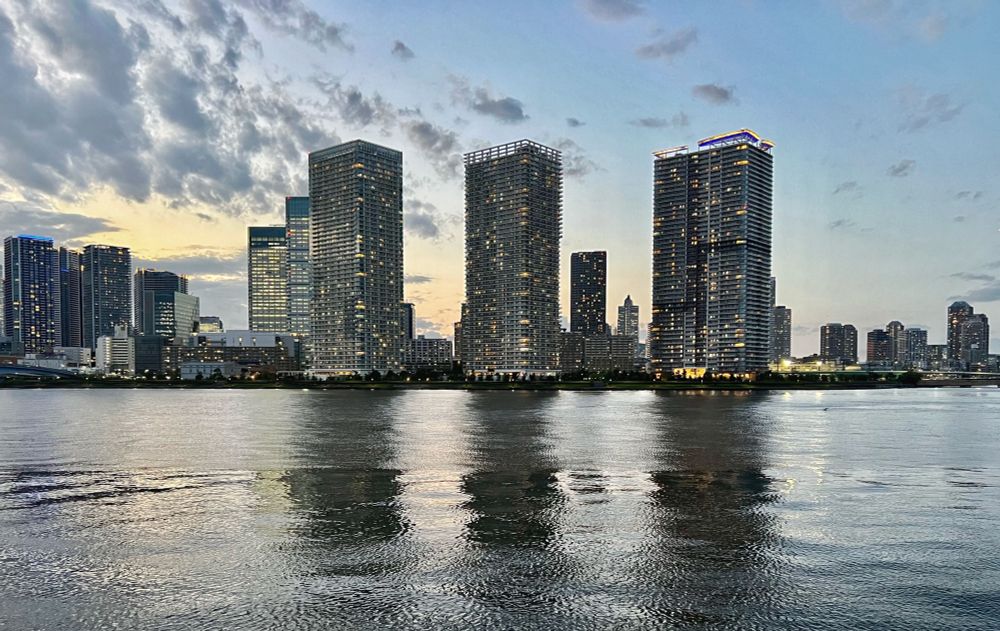 City skyline with skyscrapers reflecting in the water.
