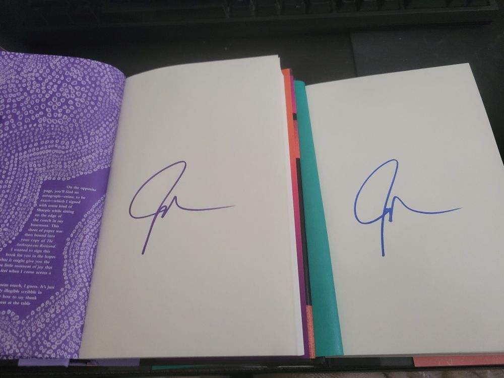 the two books again side-by-side, this time both opened to the pages containing john green's signature