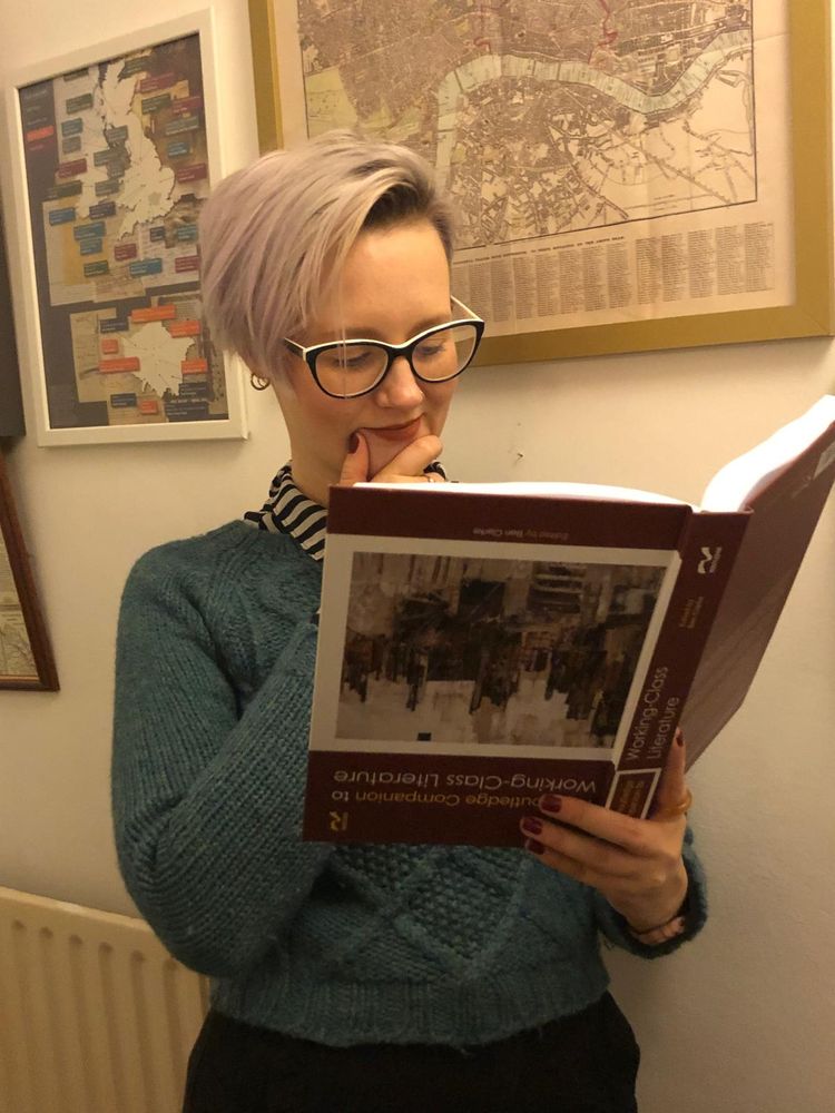 Vic is holding her copy of the book upside down trying to read it.