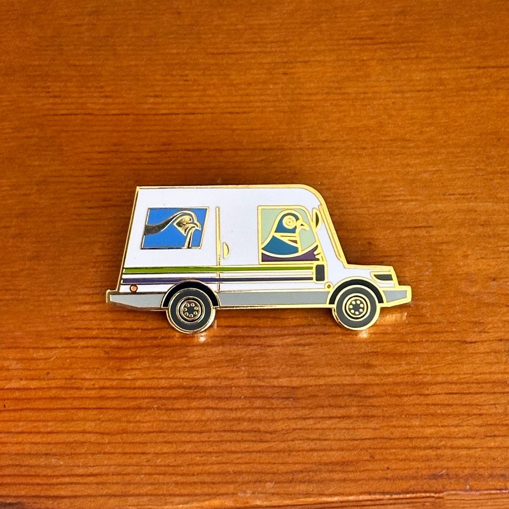 Enamel pin featuring a pigeon piloting an Oshkosh NGDV-style mail truck. The USPS logo is also a pigeon. 