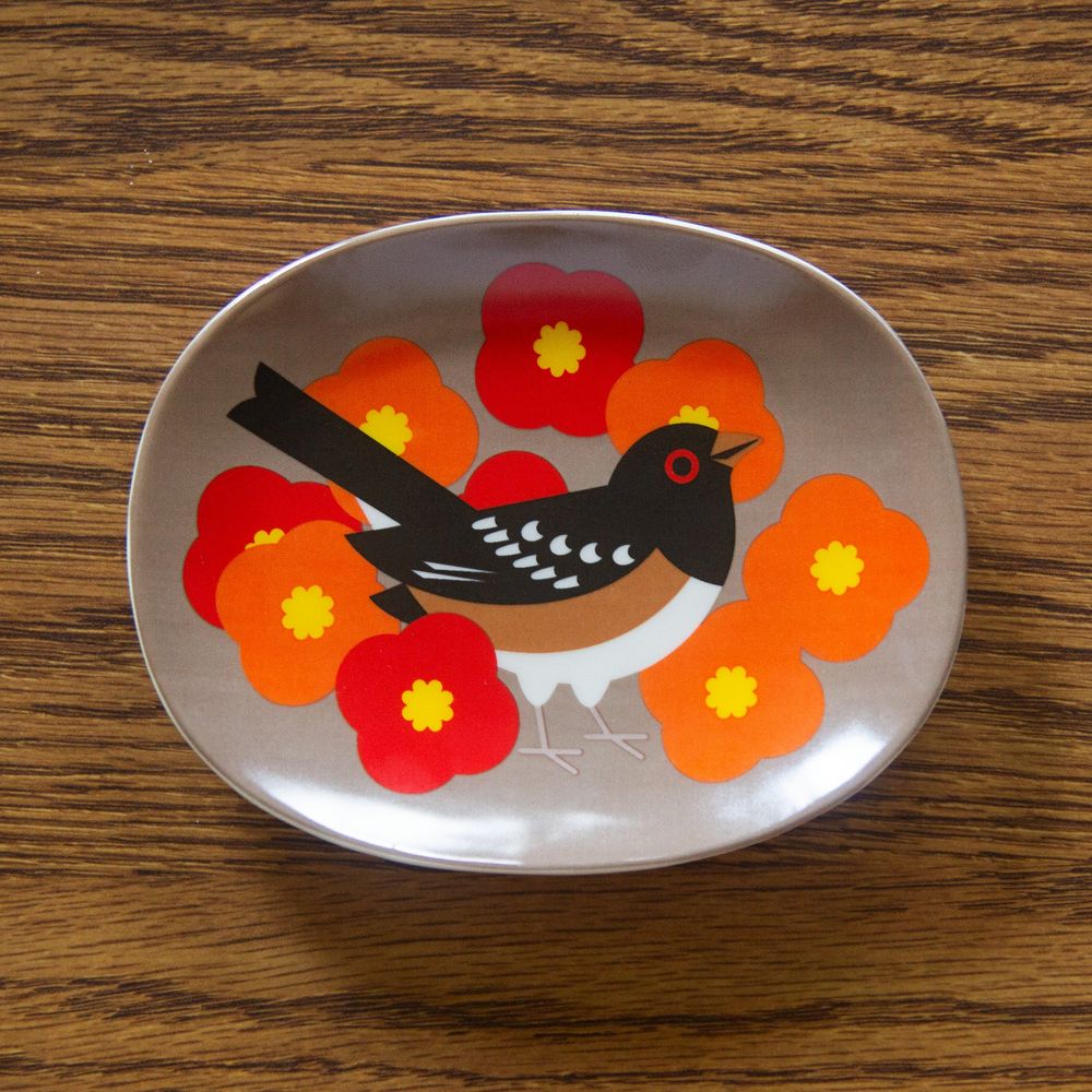 Brown oval-shaped tray featuring an illustration of a Spotted Towhee amongst poppies. 