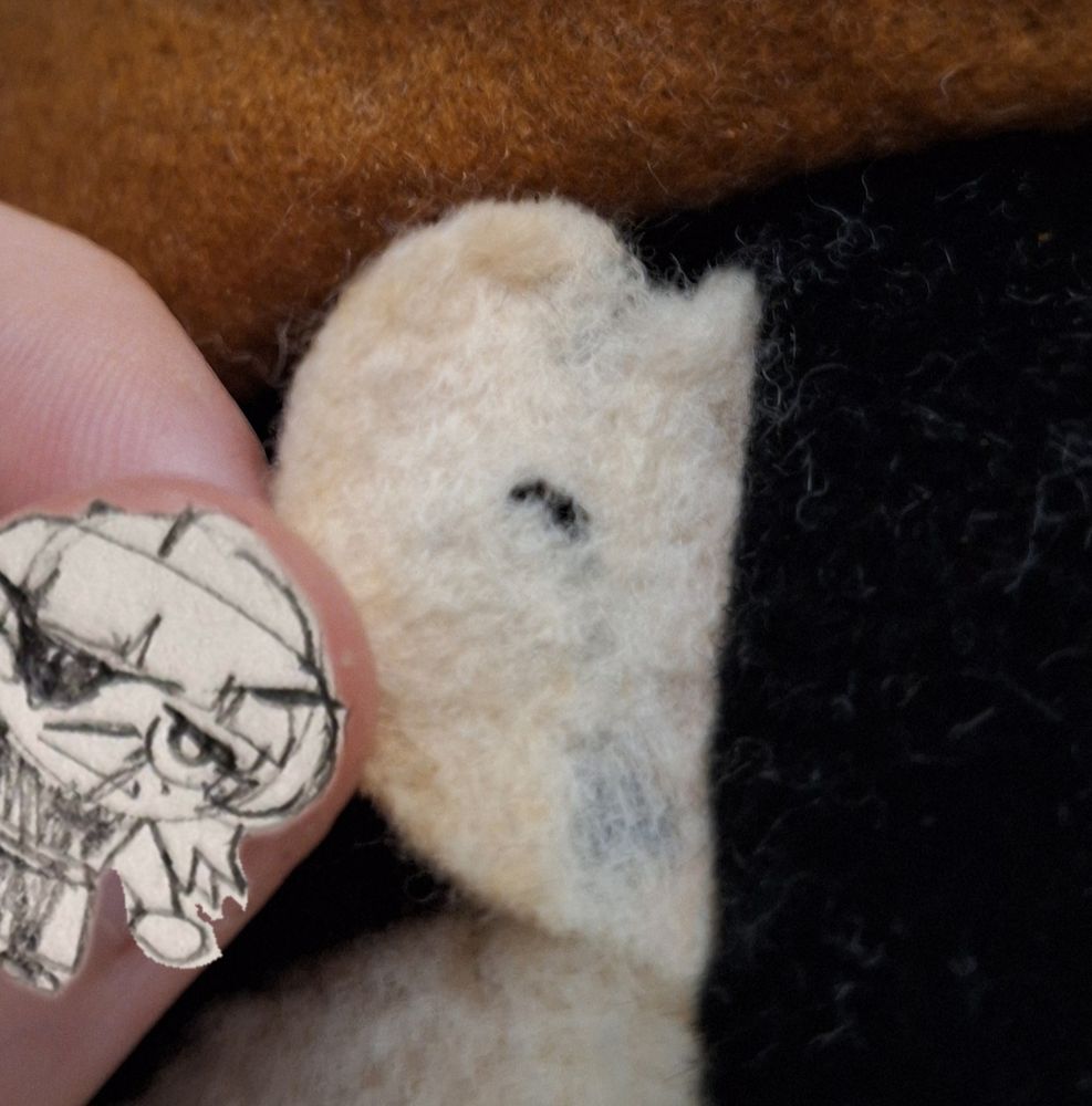 Closeup picture of a plushie's ear made of an old flimsy fabric (surely felt). A hole and parts with visibly less fabric make it seem like the ear is ripping off