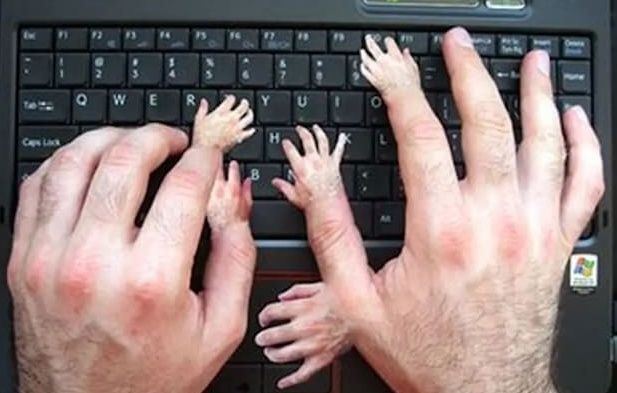 hand with multiple fingers on a computer keyboard