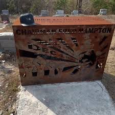 Same headstone covered with a metal bulletproof casing that reads “Chairman Fred Hampton”