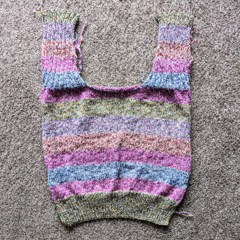 A striped jumper made up of heathered colours of green, purple, blue and orange.