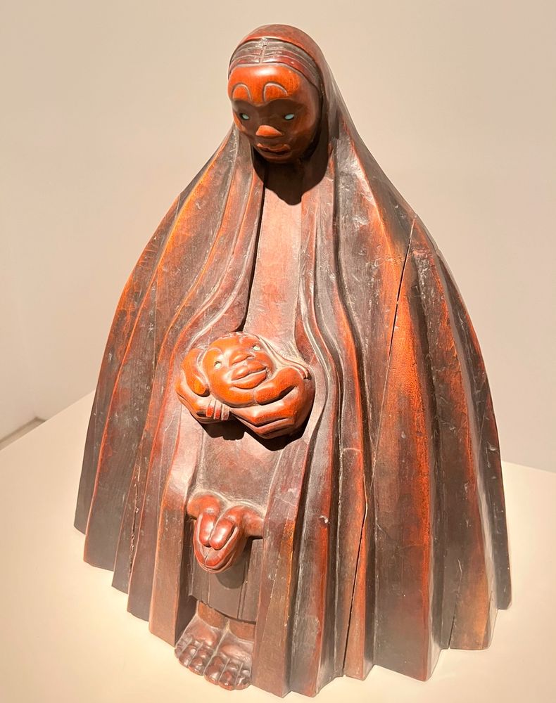 双手捧着小孩脸的妈妈（木雕）