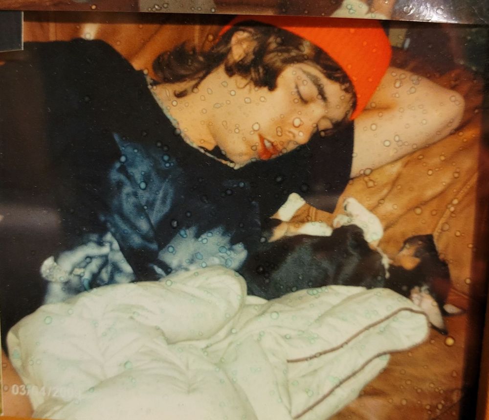 Beloved nephew sleeping with his pup. Looks like a redneck hipster from Vermont. Pup appears to cradled by hand, but it's a folded blanket.