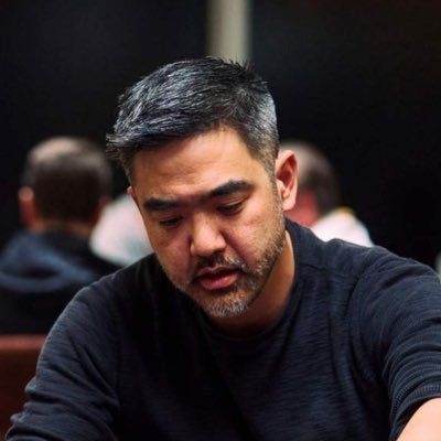Ian Chan playing poker. Ian is a middle-aged Asian man with black hair and a short, salt-and-pepper beard.