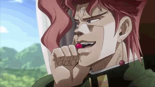 a man with red hair is eating a red cherry