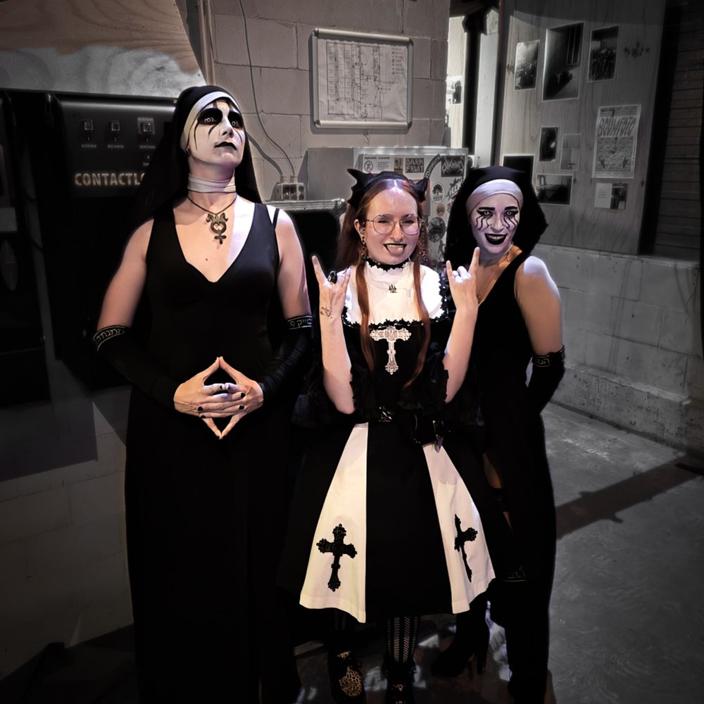 Two members of the band DOGMA (Rusalka and Lamia) in their nun attire and corpse paint with me in the middle, wearing a black and white nun inspired coord with cross appliques putting up devil horn signs with both hands.

Coord details
Headdress: Antique BeasT
Collar and jsk: Moi-même-Moitié
Blouse: Metamorphose
Ring and belt: Vivienne Westwood
Petticoat: Melikestea
Tighs: Snag tighs
Shoes: Underground UK