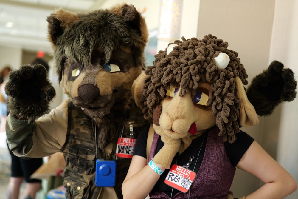 A brown colored canine, and a brown colored sheep fursuiter posing for a picture at the chomp event.
