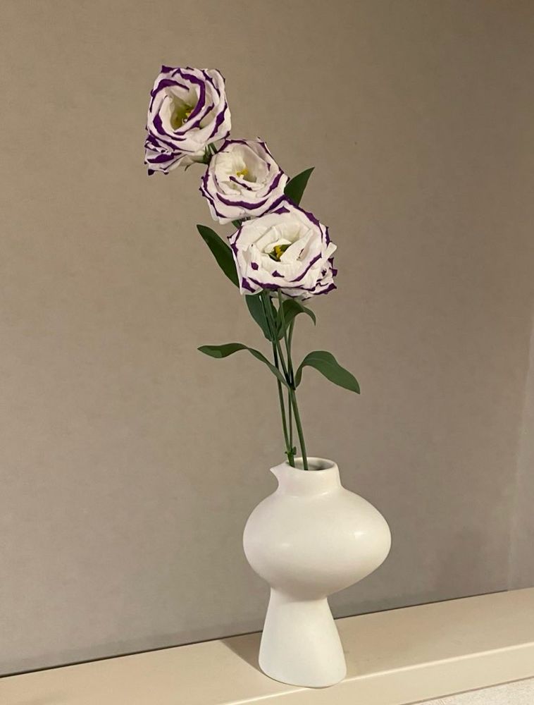 白い鳥の花瓶にトルコキキョウが差してある。花は3輪。白に紫の縁取り。