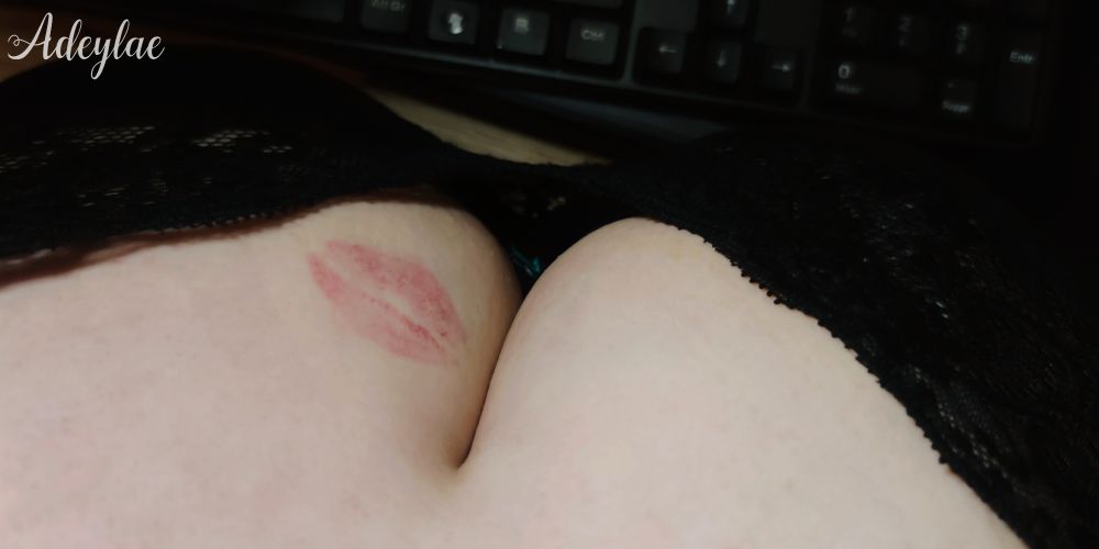 Photo du décolleté d'une femme, une trace de rouge à lèvres visible sur le haut de son sein gauche