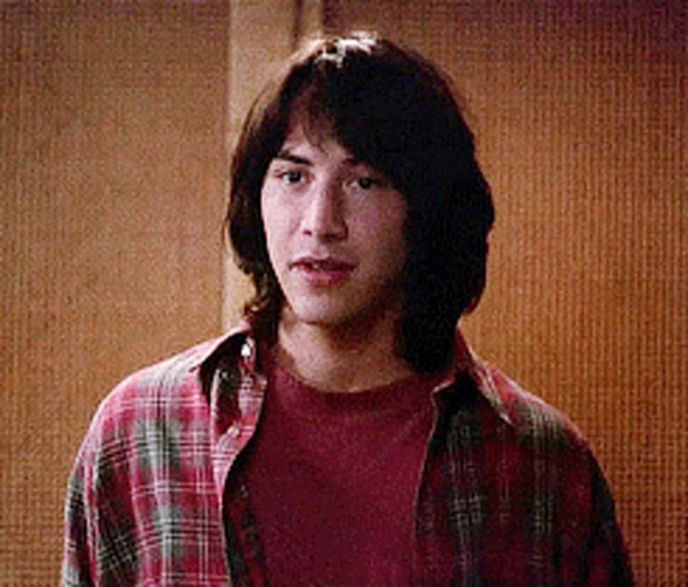 a young man wearing a red shirt and plaid shirt