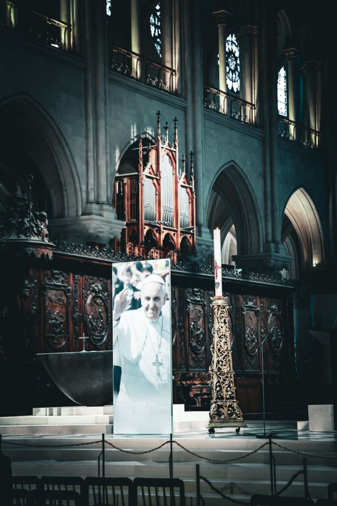 A large photo of Pope Francis next to the Paschal candle in front of the altar at Notre-Dame de Paris