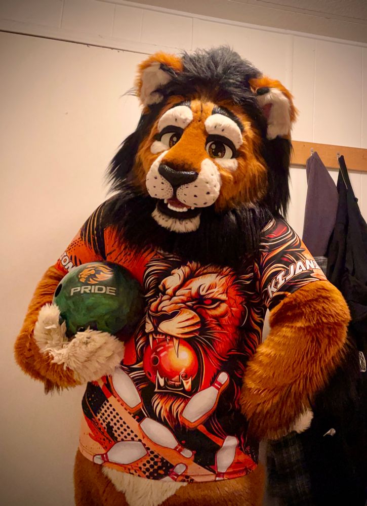 Kijani Lion wearing a custom bowling jersey with a ferocious lion on the front and his name on the sleeve, holding the Pride Empire bowling ball from Motiv Bowling