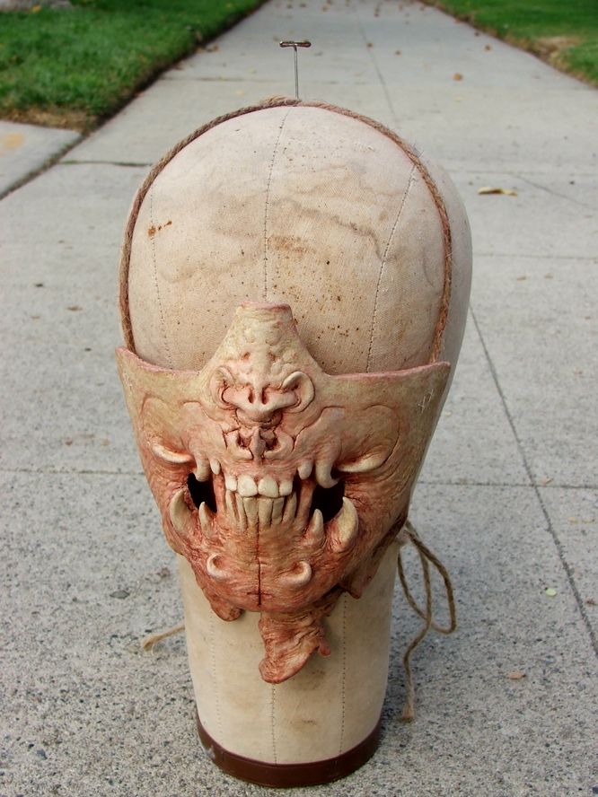 Sculpture of a toothy demon mouth + strange nose and shredded neck skin. Cast as a latex mask mouthpiece, pinned onto an antique mannequin head.