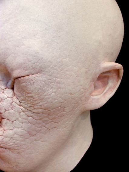 A latex mask. It has somewhat human features, with skin detail resembling a dry lake bed. There's a blood-red color painted into the cracks.