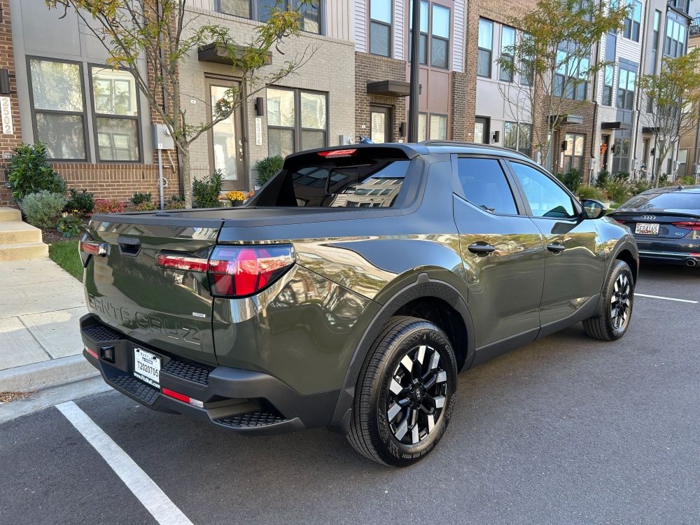 A dark green Hyundai Santa Cruz car/pickup, the smallest vehicle you can buy with a bed in the US as of 2025.