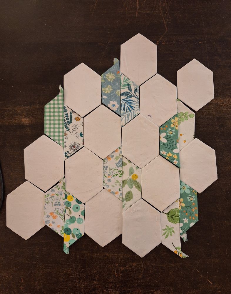 A photograph of EPP quilting pieces arranged in an odd tiling pattern. 