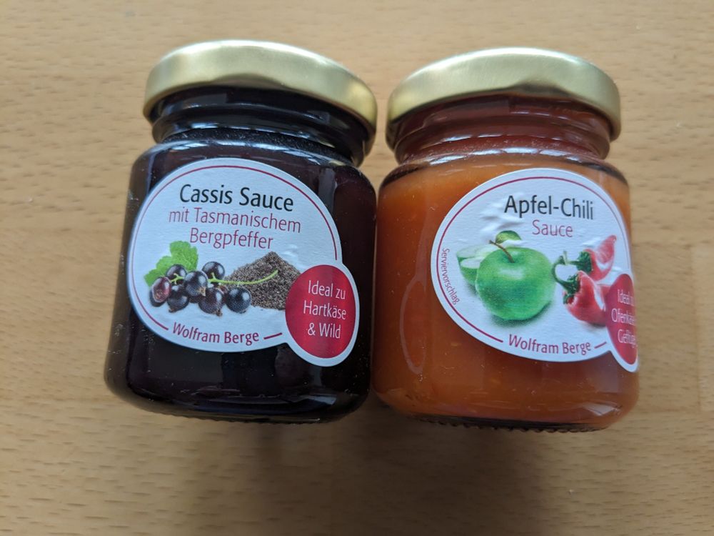 2 kleine Gläser mit Käse-Saucen:
"Cassis Sauce mit tasmanischem Bergpfeffer - ideal zu Ofenkäse & Geflügel" und
"Apfel-Chili Sauce - ideal zu Hartkäse und Wild"