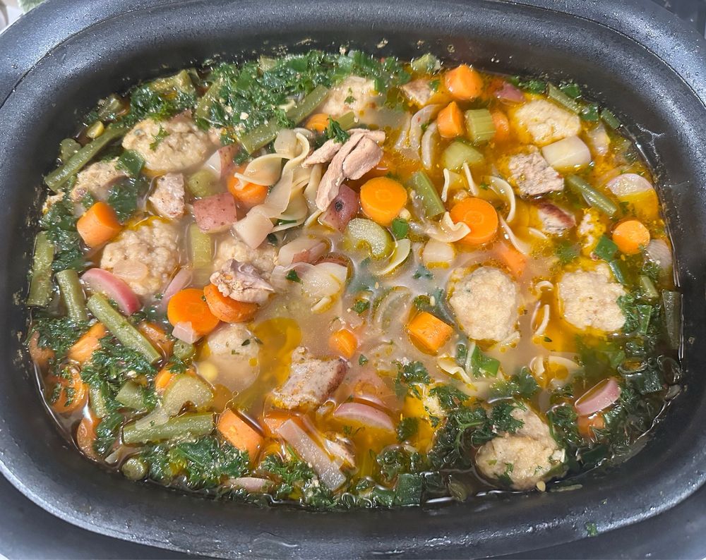 Chicken and egg noodle soup filled with kneidlach and veggies