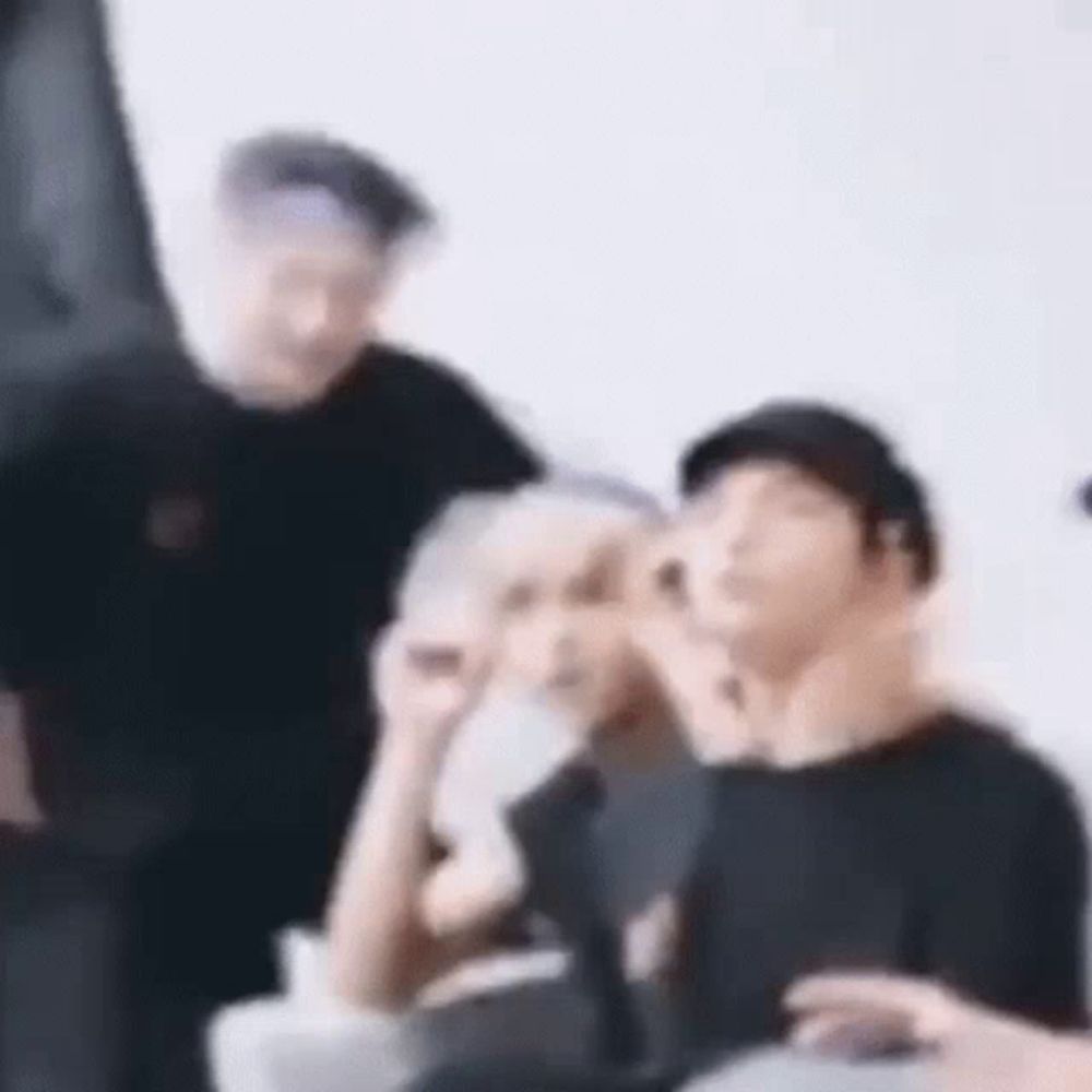 a blurry picture of a group of people standing next to each other in a room .