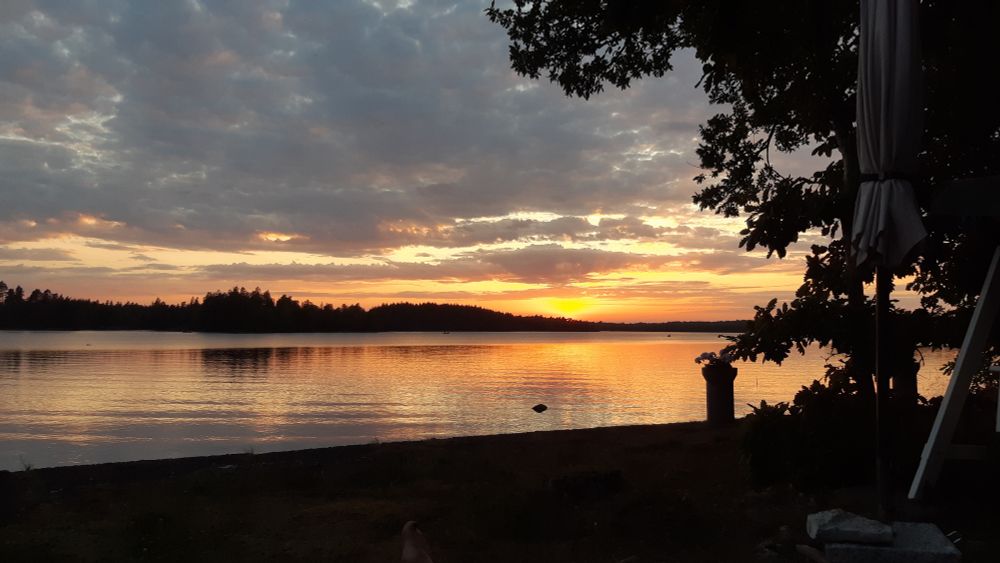 Sonnenuntergang am Åsnen-See. Normale Bewölkung, die Sonne färbt den Himmel in Pastellfarben.