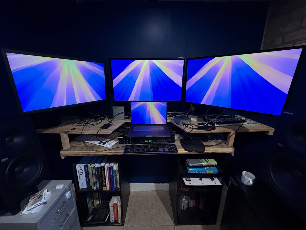 Three external monitors + MacBook Pro 16" M1 Ultra + Mac Mini M4 unified setup with CalDigit TS4.