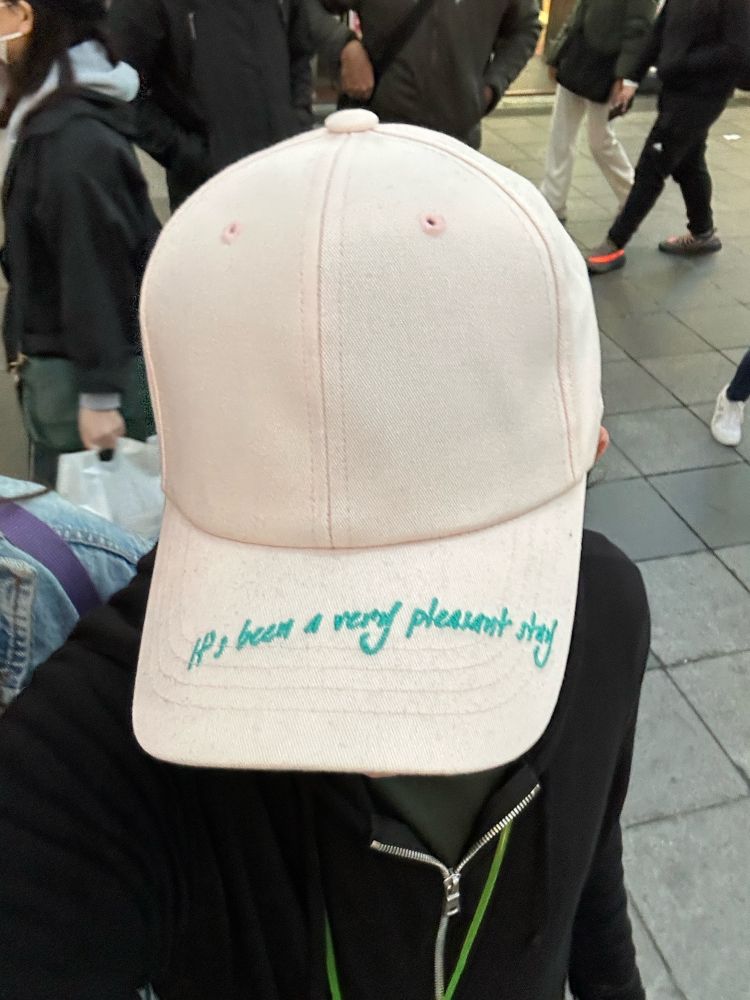 A baseball cap that says “It’s been a very pleasant stay” on its brim 