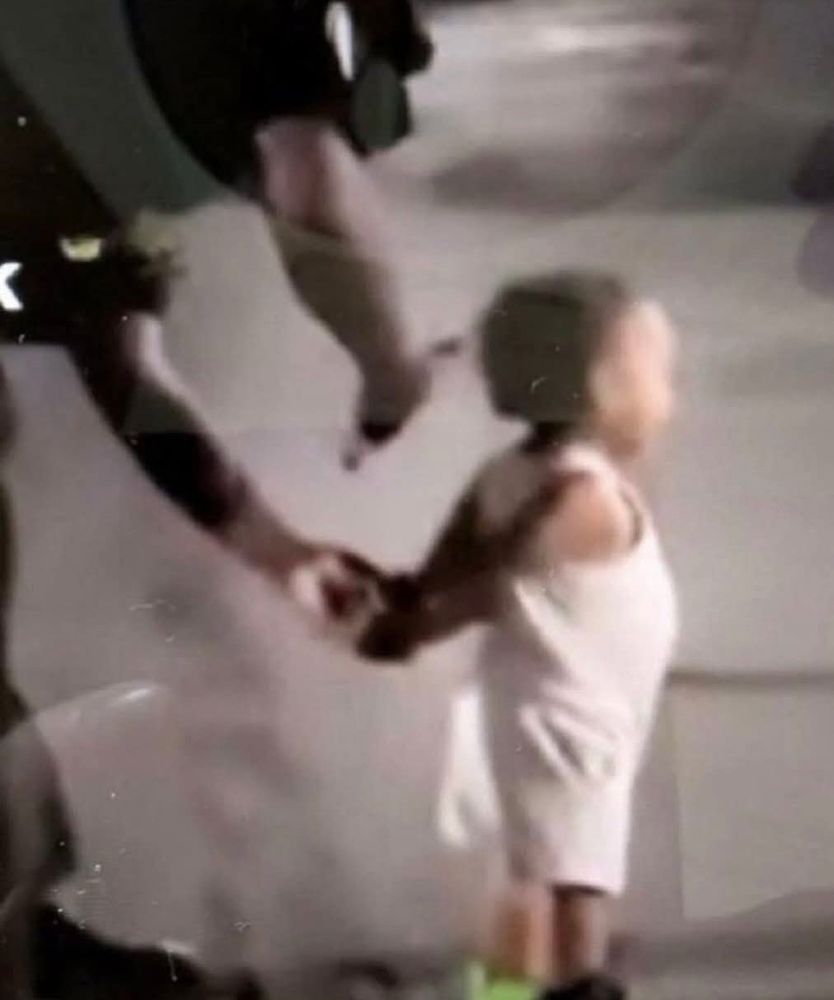 Very young child being zip tied by ICE in the night. 