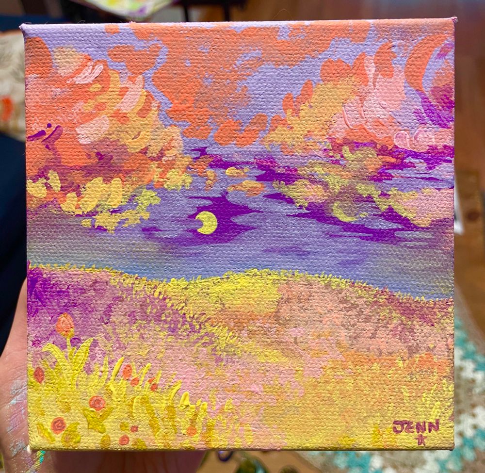 A flower dotted hillside with a full moon hanging low in the sky, illuminating the grass. Bright warm clouds frame the nearly fog covered moon. Tulips bloom in the foreground. Signed Jenn, with a star.