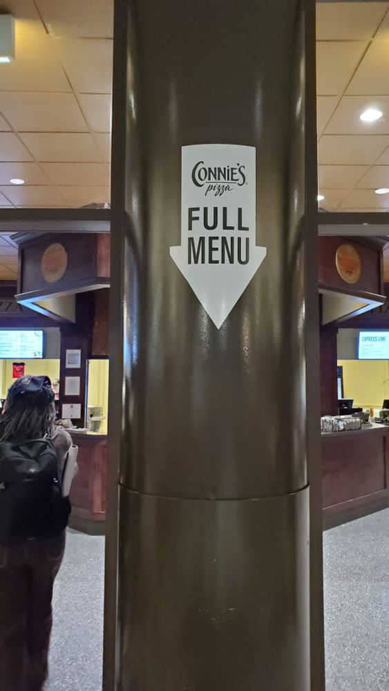A sign reading "Full Menu" with an arrow pointing to a blank wall. 