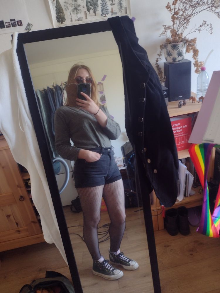 mirror selfie of my outfit for today, black shorts with fishnets, and a forest green long sleeved top