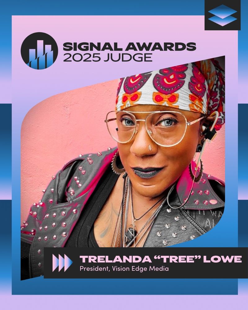Image Description: An African American woman softly smiles to the camera, wearing a multicolor hair wrap, leather jacket, tank top, eyeglasses necklaces, lip ring, earrings and headphones.