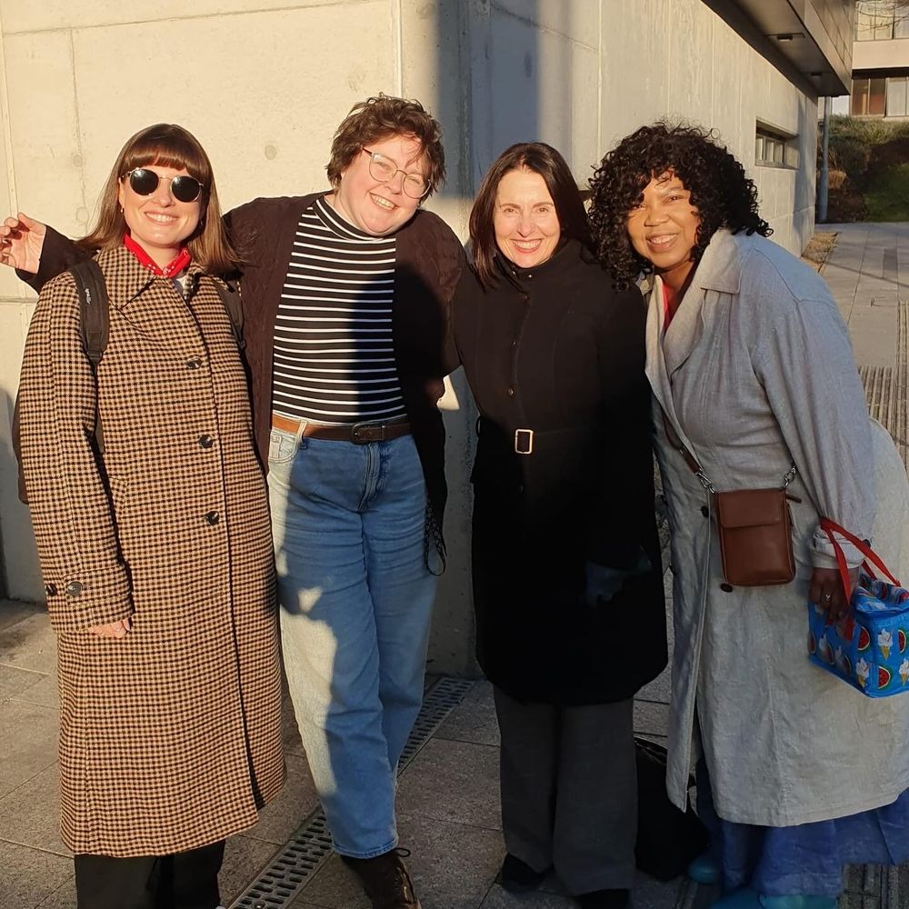 Cheryl with three Red Ladder trustees (past and present) arms round each other smiling in the sunshine