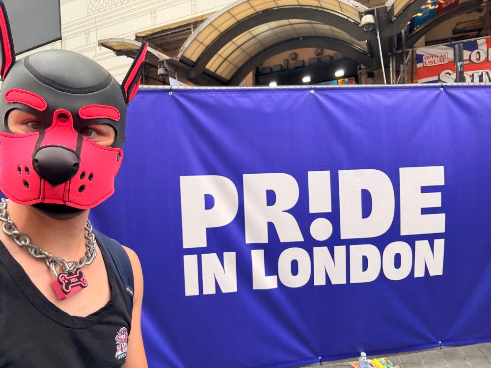 Me in front of sign that reads “Pride in London”