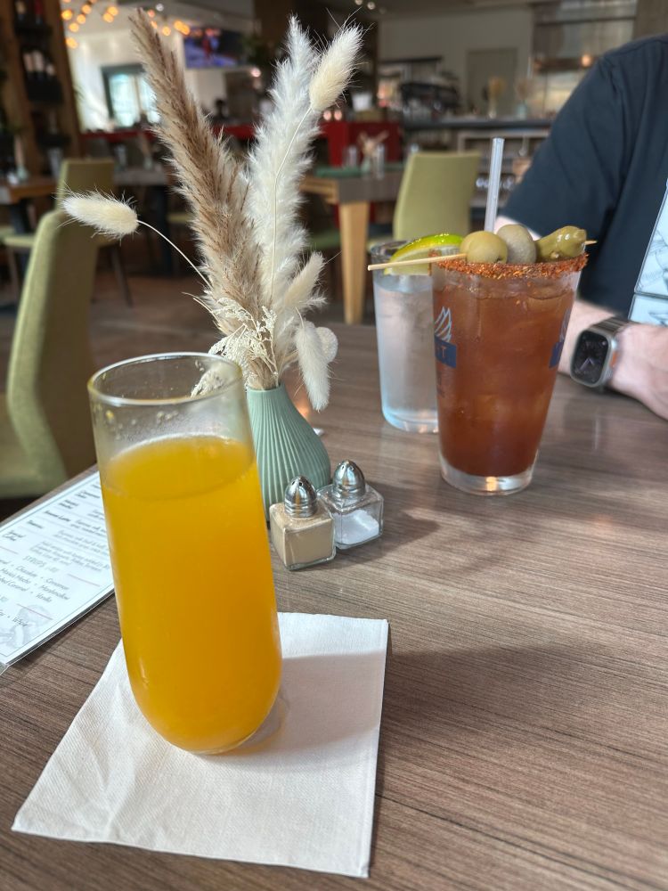 A brunch table featuring a mango mimosa and a Bloody Mary 