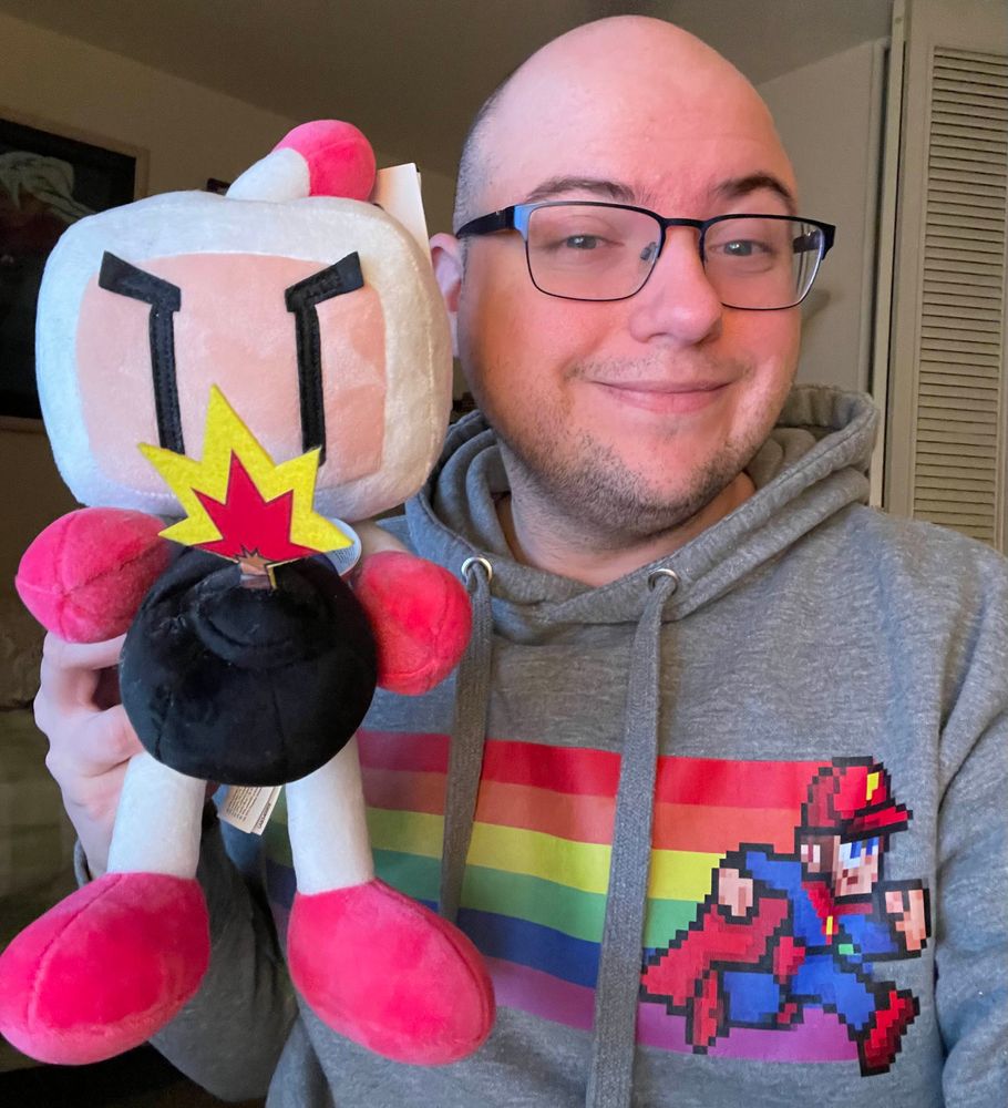 Me smiling and holding up a Bomberman plushie