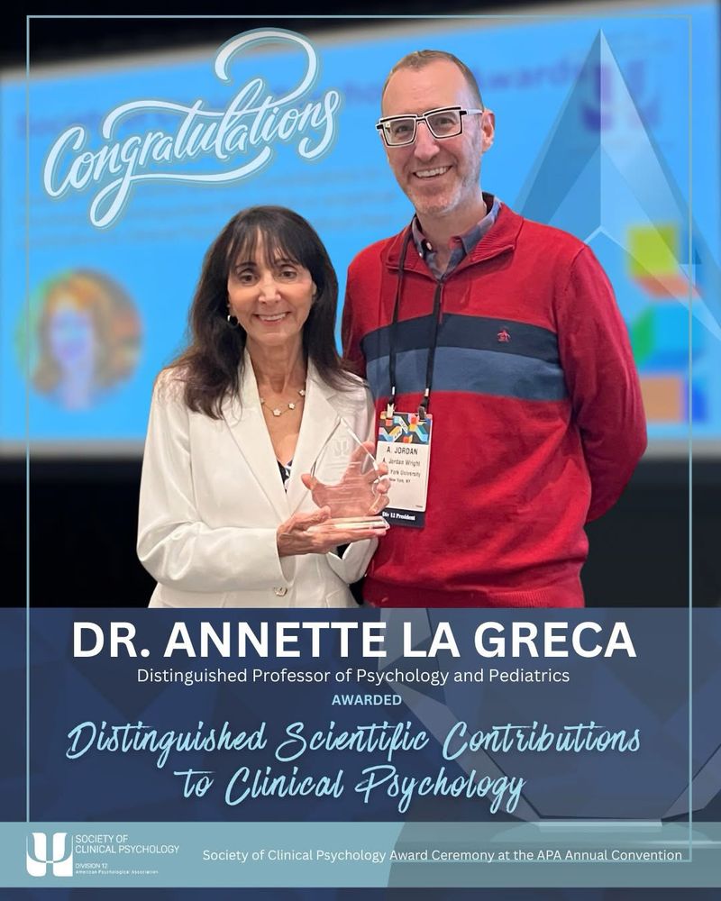 Smiling woman holding award next to smiling man.