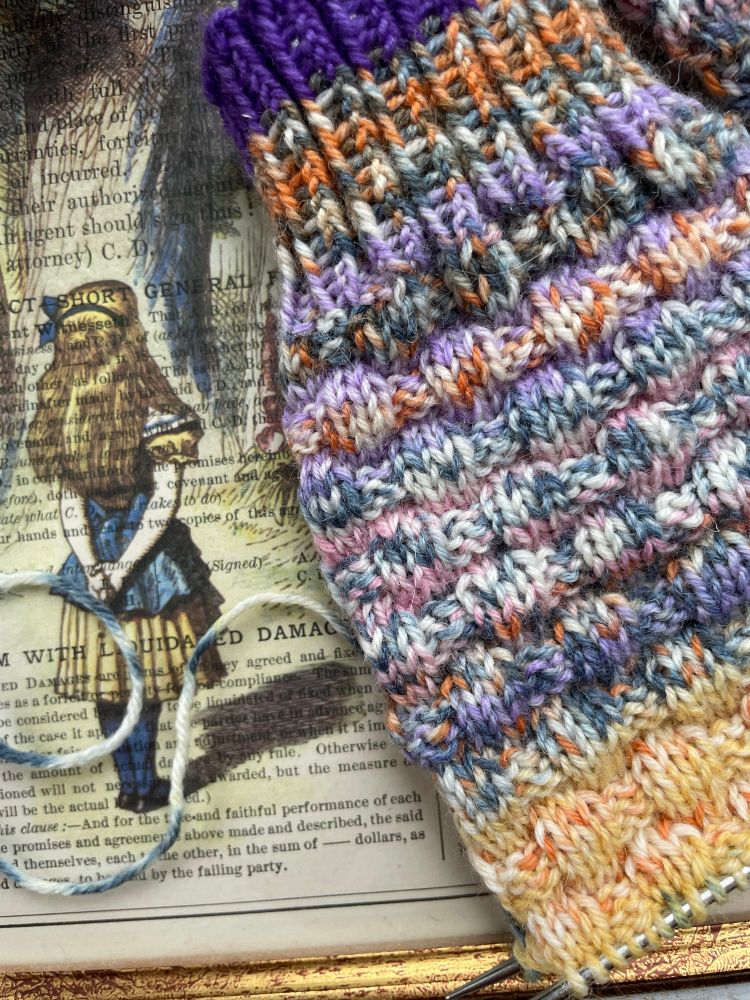 Alice auf Papier gedruckt und eine Stricksocke 